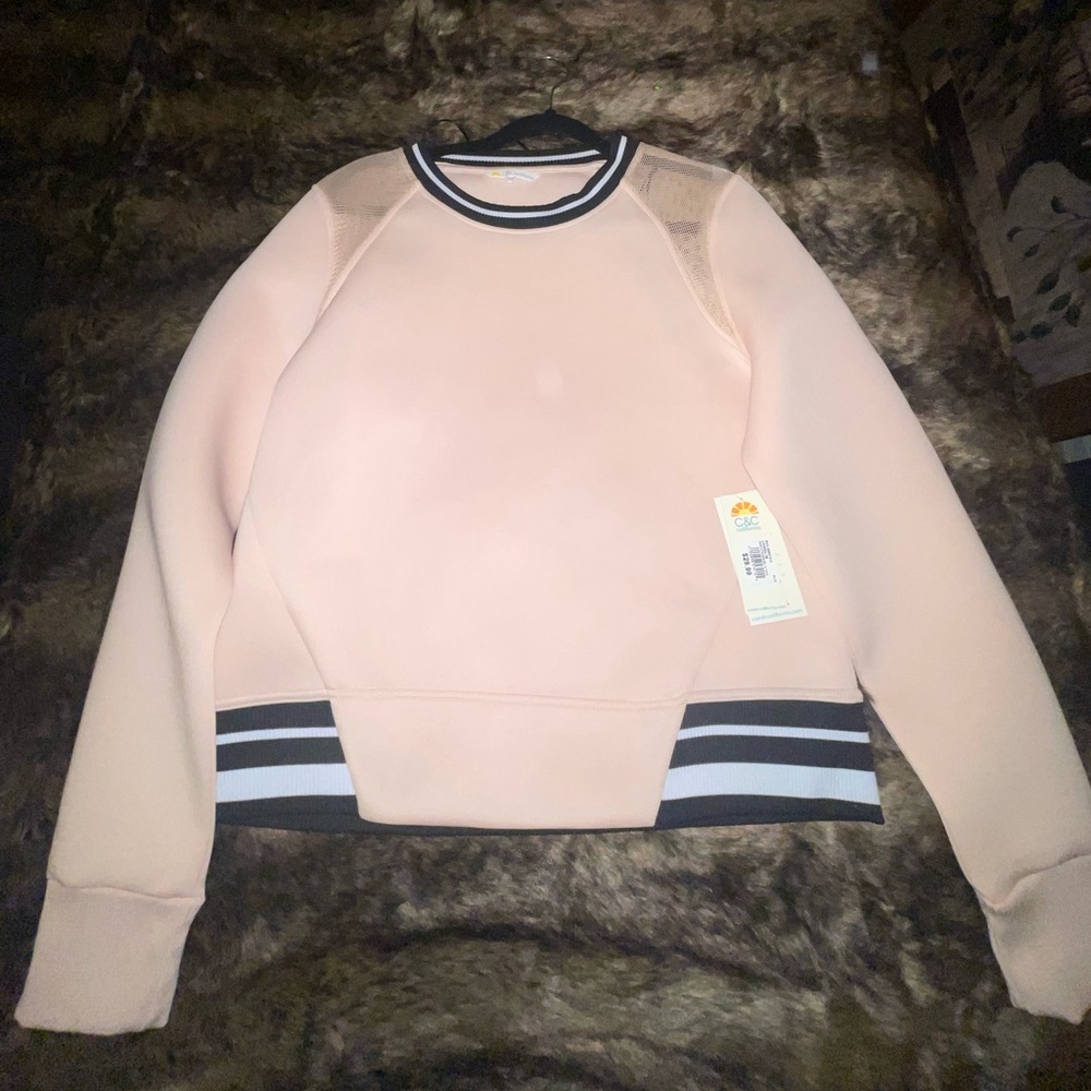 Pink crew neck with stripes on bottom and mesh shoulders